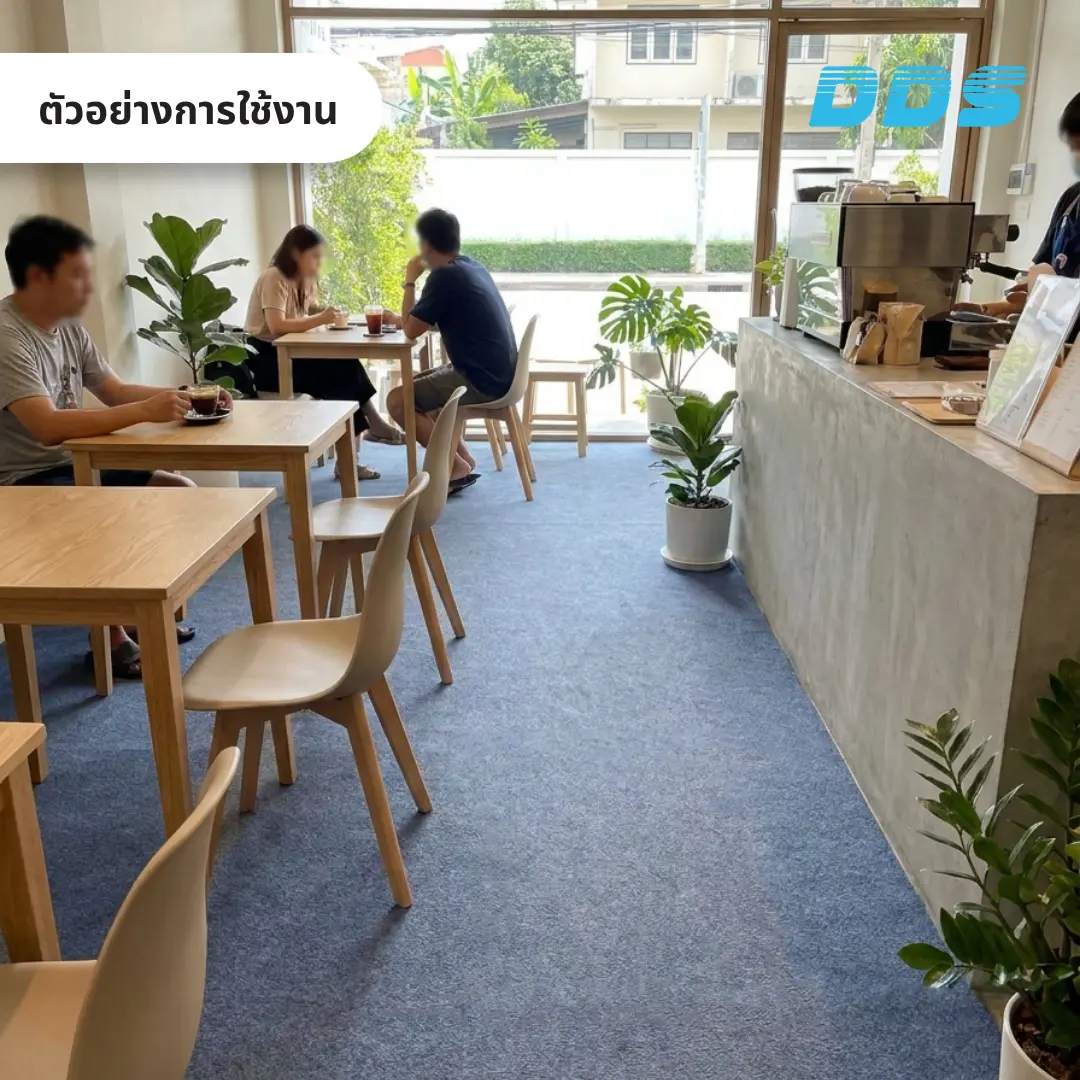 ภายในคาเฟ่ มีโต๊ะเก้าอี้สำหรับนั่งรับประทานอาหารและต้นไม้ตกแต่ง